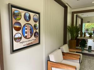 a living room with a picture on the wall at Hotel Golden JK in Muriaé