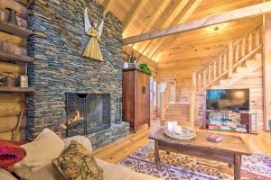 a living room with a stone fireplace in a cabin at Superb Linville Mountain Cabin with Wraparound Decks in Linville