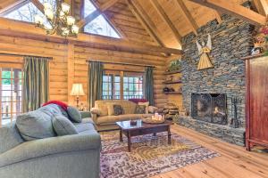 uma sala de estar com um sofá e uma lareira em Superb Linville Mountain Cabin with Wraparound Decks em Linville