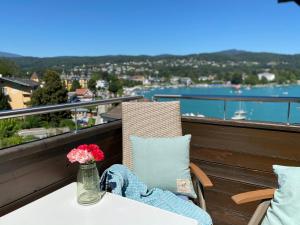 stół z wazonem z kwiatami na balkonie w obiekcie Apartment Veldener Bucht by Seebnb w mieście Velden am Wörthersee