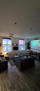 a living room with couches and a large screen at Smart Town Centre Apartments in Northampton