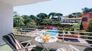 a balcony with a table and chairs and a pool at El Trull Apartaments in Lloret de Mar