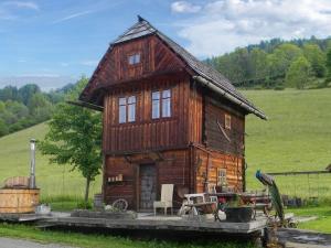 mały drewniany dom na środku pola w obiekcie Hüttenferien Köberlhof w mieście Sankt Georgen ob Murau