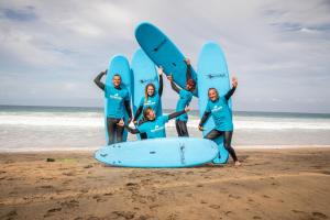 a group of people standing on the beach with surfboards at Surfescape Fuerteventura in Lajares