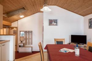 a kitchen and dining room with a table and a television at Ladinser Hof Reiterstube in Castelrotto