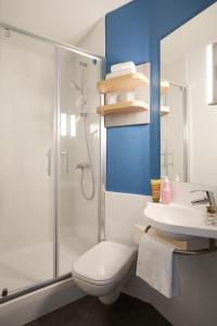 a bathroom with a shower and a toilet and a sink at Ibis Budget - Lille Villeneuve D'Ascq in Villeneuve d'Ascq