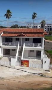 Casa blanca con techo rojo y valla blanca en Pousada Aconchego Sol e Mar, en Maragogi