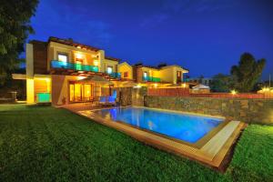 a villa with a swimming pool in front of a house at Horizon Line Villas in Kiotari