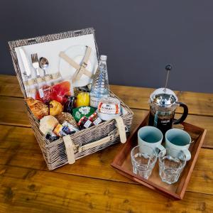 a picnic basket with food and drinks on a table at Vanbrugh House Hotel in Oxford