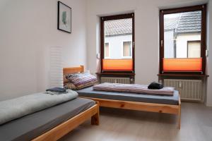 two beds in a room with two windows at 3 Zimmer Wohnung für max. 5 Personen in Alzey