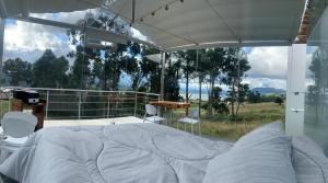 ein Schlafzimmer mit einem großen Bett und einem großen Fenster in der Unterkunft Glamping Cristal in Guatavita