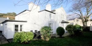 una casa blanca con algunos arbustos delante de ella en Hill House Clifden, en Clifden