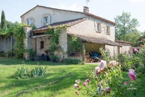 Domaine des clauzes في Fauch: منزل حجري قديم في حديقة بها زهور