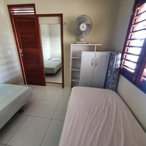 a small room with a refrigerator and a mirror at Casa na Praia de Águas Belas - Caponga in Caponga