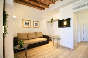 sala de estar con sofá y TV en la pared en Espinach Port Serrallo, en Tarragona