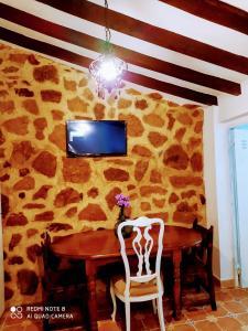 una sala da pranzo con tavolo e parete di roccia di Casa Pepa ad Algar