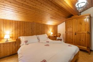 ein Schlafzimmer mit einem großen Bett und Holzwänden in der Unterkunft Agritur Broch in Fiera di Primiero