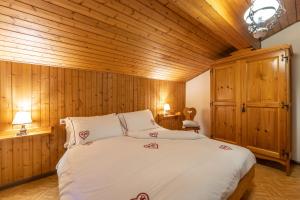 sypialnia z dużym łóżkiem i drewnianymi ścianami w obiekcie Agritur Broch w mieście Fiera di Primiero