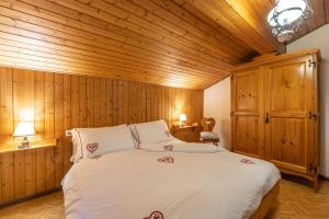 - une chambre avec un grand lit et des murs en bois dans l'établissement Agritur Broch, à Fiera di Primiero