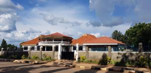 una casa con techos rojos y una valla en Northern Pearl, en Gulu