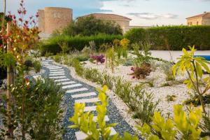 un jardín con un camino de piedra en el medio en Villa No 1 - Cap St Georges Resort, en Peyia
