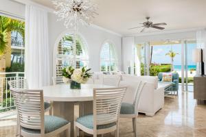a living room with a dining room table and chairs at The Tuscany on Grace Bay in Grace Bay
