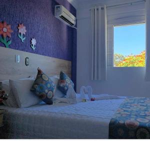 a bedroom with a white bed with a window at Pousada Aconchego de Minas in Juiz de Fora