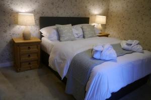 a bedroom with a large white bed with blue pillows at Rosedale Cottage in Rosedale Abbey