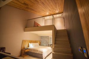 Un dormitorio con una cama elevada y una escalera en LE LE Motel, en Pingtung City