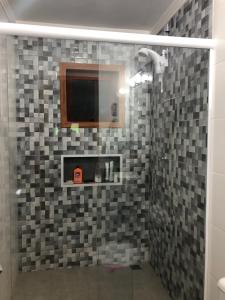 y baño con ducha y pared de azulejos. en Surfer paradise, en Praia do Rosa 52 fotos más