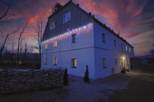 a white house with christmas lights on the side of it at Siedlisko Krasna in Świeradów-Zdrój