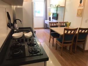 una cucina e una sala da pranzo con piano cottura e tavolo di Flat Charme Gramado a Gramado