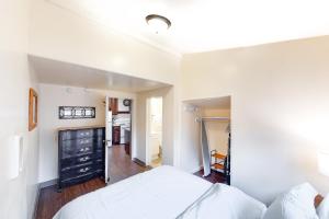 a bedroom with a white bed and a hallway at The Craftsman House in Springfield