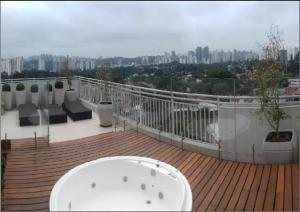 uma banheira sentada no topo de um deque em Conforto no Alto da Boa Vista em São Paulo