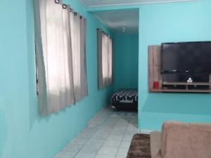 a living room with blue walls and a tv at Casa De férias in Manaus