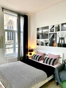 1 dormitorio con 1 cama con almohadas rosas y negras en BONJOUR Apartments Сentre 3 en Amberes