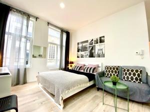a bedroom with a bed and a couch and a table at BONJOUR Apartments Сentre 3 in Antwerp