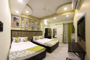 - une chambre avec 2 lits et une télévision dans l'établissement HOTEL 86B, à Kolkata