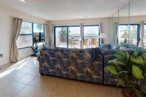 uma sala de estar com um sofá e vista para o oceano em 101 - Sandy Shores em St. Pete Beach