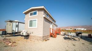 a tiny house is sitting on a gravel yard at FunStays Glamping Tiny House Double Loft Site 6 in Moab