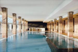 a swimming pool with blue water in a building at Domaine des Dryades in Pouligny-Notre-Dame
