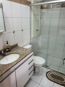 a bathroom with a sink and a toilet and a shower at Flat à Beira Lago in Brasilia