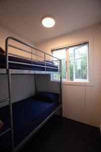 a room with two bunk beds and a window at Waiheke Backpackers Hostel in Onetangi