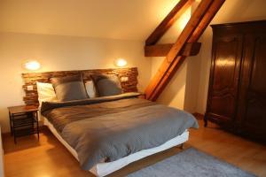 sypialnia z dużym łóżkiem z drewnianym zagłówkiem w obiekcie Chambres d'hôtes Les Peschiers w mieście Chateauroux-les-Alpes