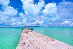 a group of people walking on a pier in the water at ANA InterContinental Ishigaki Resort by IHG in Ishigaki Island +156 photos