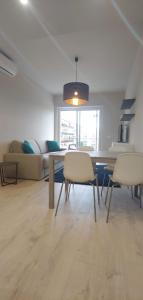 salon ze stołem, krzesłami i kanapą w obiekcie ViCo HomeSuite w mieście Milazzo
