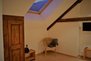 a attic room with a skylight and a chair at Chambres d'hôtes Les Peschiers in Chateauroux-les-Alpes