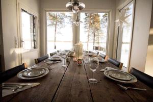 a wooden table with plates and silverware on it at Chalet Norva in Rovaniemi