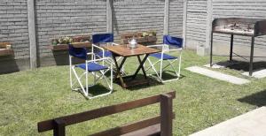 a table and chairs sitting on the grass at Arroyo Departamentos in Tandil