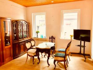 a dining room with a table and chairs and a tv at Andefu Hotel am Kantpark in Duisburg